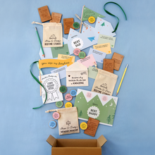 Flat lay of Clara & Macy’s heartfelt Father's Day gift collection for dads, featuring personalised bedtime story bags, wooden memory-making tokens, prompt cards, and keepsake envelopes from young children and babies, all styled on a soft blue background.