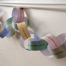 Colorful paper chain with motivational phrases on a white background