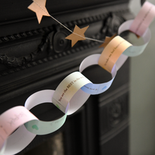 Finished Daddy Is Amazing paper chain garland hanging across a fireplace mantel, filled with handwritten Father's Day memories, compliments and messages from children.