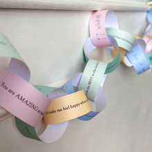 Finished Daddy Is Amazing paper chain garland hanging across a fireplace mantel, filled with handwritten Father's Day memories, compliments and messages from children.