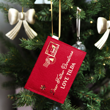 A red felt personalised Christmas envelope that read "Dear Father Christmas, Love Tilda," is hanging on a decorated Christmas tree with golden ribbon.
