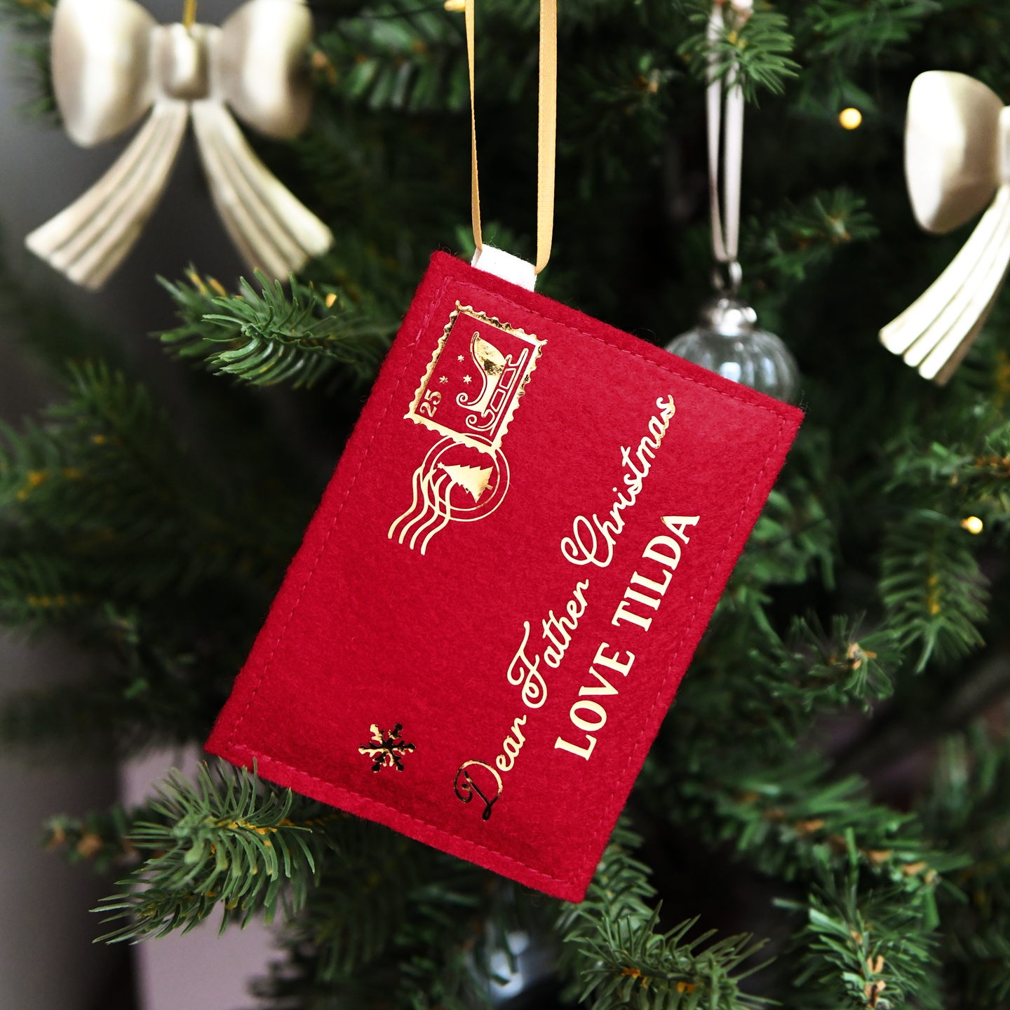 A red felt personalised Christmas envelope that read 