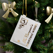A handmade felt envelope with golden words reading "The Clempson's Christmas Wishes" and a reindeer design stamp in the corner, hangs on a decorated Christmas tree.