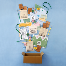 Flat lay of Clara & Macy’s heartfelt Father's Day gift collection for dads, featuring personalised bedtime story bags, wooden memory-making tokens, prompt cards, and keepsake envelopes from young children and babies, all styled on a soft blue background.