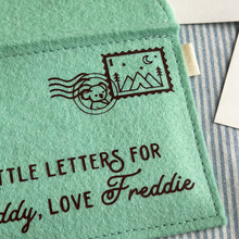 The corner of a handmade green felt envelope with a camping design stamp and a koala postmark in the top right hand corner.