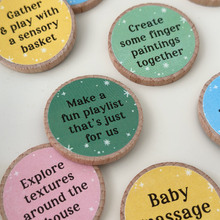 A collection of colourful wooden activity tokens for new dads and babies displayed on a white tray. Each eco-friendly token features bonding prompts such as “Tummy time fun,” “Read our favourite story book,” and “Capture sweet & silly family photos together.” Part of a heartfelt Father's Day gift set designed to inspire memory-making moments between Daddy and baby.