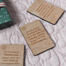 Three wooden story cards lay on a pink quilt. Each card has a story idea engraved in it. The cards are designed for young children to use when telling bedtime stories.